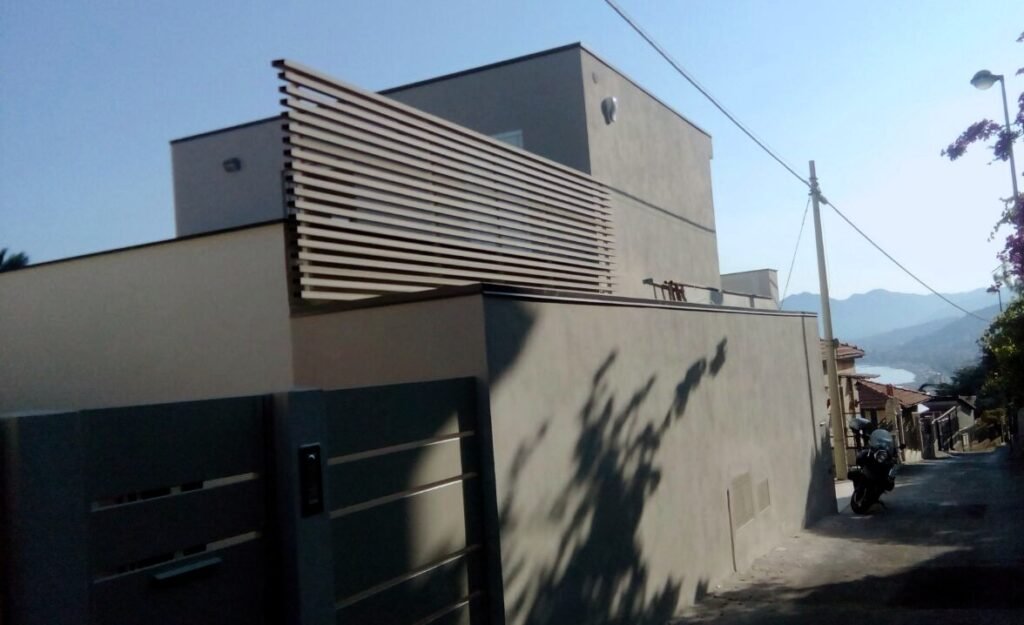 Nuova costruzione di villa moderna con tetto piano, frangisole in legno e vista mare a Borgio Verezzi in provincia di Savona